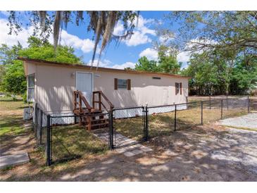 Charming single-story home featuring well-maintained yard, fenced perimeter, and inviting front entrance with wood stairs at 33506 Luana Ct, Leesburg, FL 34788