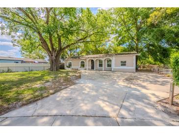 Charming single-story home with a spacious front yard and inviting curb appeal enhanced by mature trees at 4748 Amoy Ct, Orlando, FL 32811