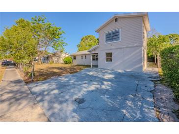 Two-story home with a concrete driveway and simple landscaping, perfect for a starter home at 4805 Okeefe St, Orlando, FL 32808