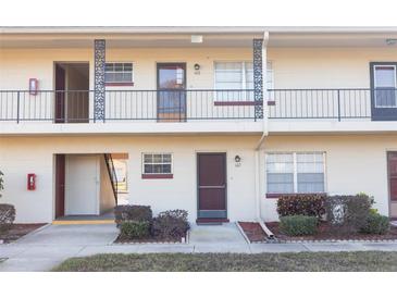 Two-story condo building featuring multiple units with individual entrances and well-maintained landscaping at 5505 Hernandes Dr # 108, Orlando, FL 32808