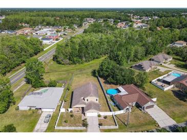An aerial view of the property showing its proximity to neighborhood and other homes, along with the in-ground swimming pool at 602 Milan Dr, Kissimmee, FL 34758