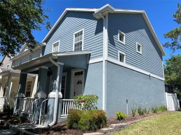 Charming two-story home featuring a light blue exterior with a welcoming front porch and manicured landscaping at 6327 Southbridge St, Windermere, FL 34786