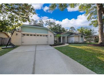 Charming single-story home with a well-manicured lawn, a long driveway, and an attached two-car garage at 659 N Endeavour Dr, Winter Springs, FL 32708