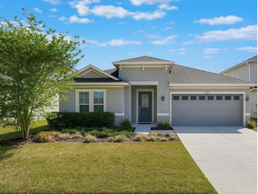 Inviting single-story home with a neatly manicured lawn and a two-car garage at 902 Grand Hilltop Dr, Apopka, FL 32703