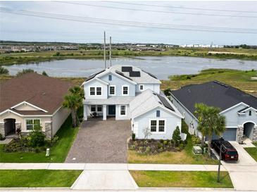 Beautiful two-story home with paver driveway and solar panels near the lake and lush landscaping at 2926 Crest Wave Dr, Clermont, FL 34711