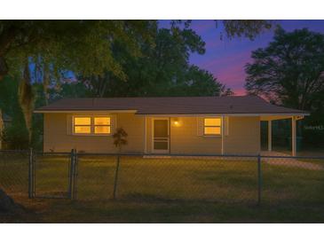 Charming home with a cozy front yard and welcoming entrance, illuminated by warm light at dusk at 1531 Jefferson Dr, Mount Dora, FL 32757