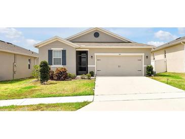 Charming single-story home featuring a two-car garage, landscaped yard, and inviting front entrance at 260 Lake Smart Cir, Winter Haven, FL 33881