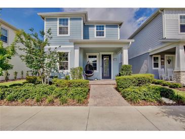 Charming two-story home featuring a lovely front porch and professionally landscaped yard with attractive shrubbery at 14374 Lanikai Beach Dr, Orlando, FL 32827