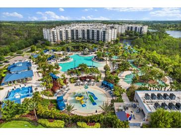 Stunning aerial view of resort pools, slides, palm trees, and the condo buildings at 14501 Grove Resort Ave # 3335, Winter Garden, FL 34787