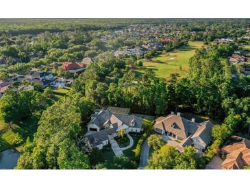 Aerial view of a luxury home surrounded by lush trees and a golf course at 1906 Oakbrook Dr, Longwood, FL 32779