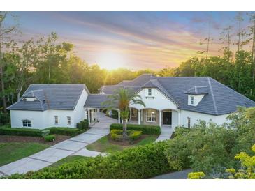 Beautiful home exterior with mature landscaping, tiled roof, and inviting driveway at sunset at 1906 Oakbrook Dr, Longwood, FL 32779