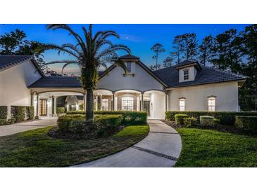 Stunning home exterior with lush landscaping and elegant architectural details at twilight at 1906 Oakbrook Dr, Longwood, FL 32779