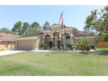 Charming single Gathering home with landscaped front yard and attached garage with large lawn and American flag at 3200 Town And Country Rd, Oviedo, FL 32766