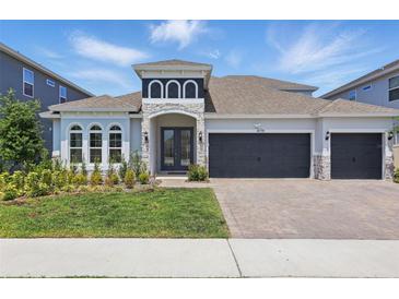 Beautiful two-story home with a three car garage, well-manicured lawn, and stone accents at 4779 Cragmere Loop, Clermont, FL 34711