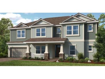Inviting two-story home featuring a covered porch and a two-car garage at 536 Moon Shell Cir, New Smyrna Beach, FL 32168