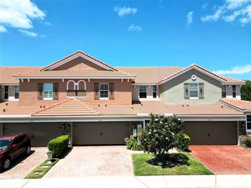 Inviting townhome with a charming tile roof, brick driveway, and well-maintained landscaping at 5510 Siracusa Ln, Sanford, FL 32771