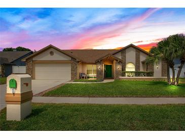 Charming single-story home with lush lawn, brick accents, and a two-car garage, creating inviting curb appeal at 5836 Goldenwood Dr, Orlando, FL 32817