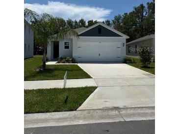 Charming single-story home featuring a two-car garage and a well-maintained front yard with green grass at 976 Commons Way, Port Orange, FL 32129