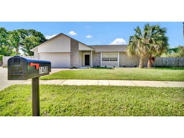 Charming single-story home with stone accents, lush lawn, and mature palm trees at 1458 Heather Way, Kissimmee, FL 34744