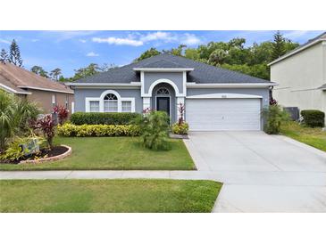 Charming single-story home featuring a manicured lawn, arched entryway, and a two-car garage at 826 Jade Forest Ave, Orlando, FL 32828