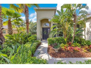 Charming front entrance with lush landscaping and inviting walkway to the front door at 12636 Hammock Pointe Cir, Clermont, FL 34711
