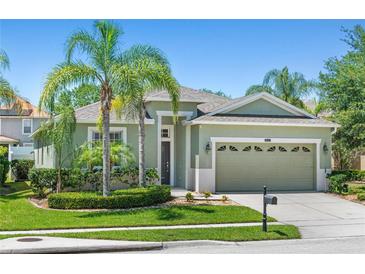 Charming single-story home with lush landscaping, mature palm trees, and a well-manicured lawn at 14137 Queenside St, Orlando, FL 32824