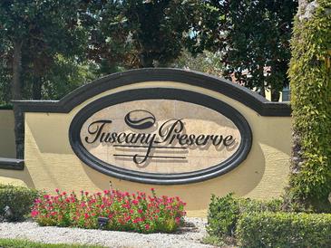 Beautiful community sign for Tuscany Preserve surrounded by flowers and greenery at 1840 Coriander Dr, Kissimmee, FL 34759