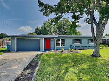 Charming single-story home featuring a vibrant red front door and well-maintained landscaping at 3220 Mahalia Pl, Orlando, FL 32805