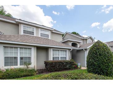 Charming exterior view of a home with a well-maintained lawn, lush green shrubbery and neutral color scheme at 127 Lake Emma Cove Dr # 127, Lake Mary, FL 32746