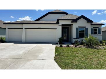 Charming single-story home featuring a three-car garage and a well-manicured lawn at 4009 Maggie Loop, Lakeland, FL 33813