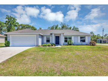 Charming single-story home featuring a two-car garage, well-maintained lawn, and beautiful landscaping at 4126 Sw 132Nd Ln, Ocala, FL 34473