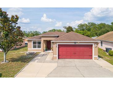Charming single-story home features a well-maintained lawn and a striking red two-car garage door at 50989 Highway 27 # 371, Davenport, FL 33897