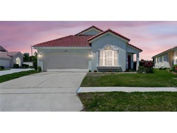 Inviting single-story home with a two-car garage, well-kept lawn, and charming architectural details at 751 Via Milano, Apopka, FL 32712