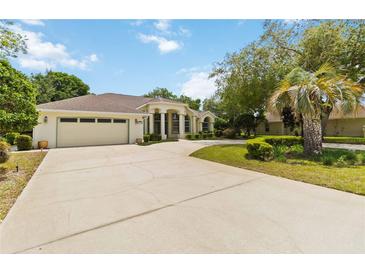 Stunning single-story home with a sprawling driveway, attached garage, and lush landscaping at 1320 Antrim Cir, Ormond Beach, FL 32174