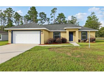 Charming single-story home featuring a two-car garage, well-maintained lawn, and lovely landscaping at 13489 Sw 60Th Avenue Rd, Ocala, FL 34473