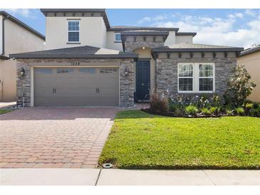 Charming two-story home with a stone facade, paver driveway and well-manicured lawn at 1539 Wynell St, St Cloud, FL 34771