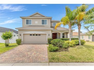 Charming two-story home with manicured landscaping, brick driveway, and a two-car garage at 16078 St Clair St, Clermont, FL 34714