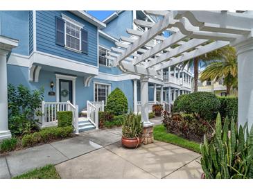 Beautiful blue townhome with pergola, well-maintained landscaping, and sidewalk at 316 Solaris Wharf St, Winter Springs, FL 32708