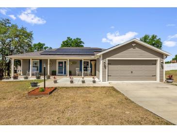 Charming single-story home with a welcoming front porch and well-maintained lawn at 326 Woodland Trl, Lady Lake, FL 32159