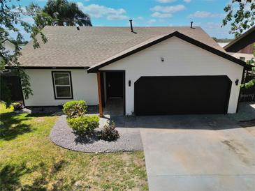 Charming single-story home with a well-manicured lawn and a black two-car garage at 3328 Fox Ridge, Winter Haven, FL 33884