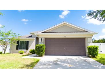 Charming single-story home with a well-maintained lawn, lush greenery, and a spacious two-car garage at 337 Giovani Blvd, Clermont, FL 34715