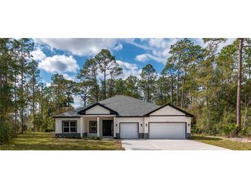 Beautiful single-story home with a manicured lawn and a two-car garage at 3777 Sw 130Th Loop, Ocala, FL 34473