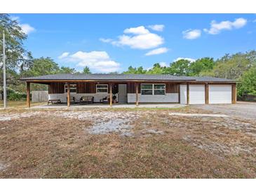 Charming exterior of home features a covered porch and a two-car garage at 424 Eden Park Rd, Altamonte Springs, FL 32714