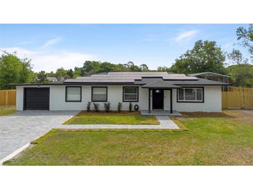 Charming, single-story home featuring a well-manicured lawn, solar panels and a freshly paved driveway at 51 Spruce Ln, Debary, FL 32713