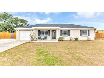 Charming single-story home featuring a well-manicured lawn and a cozy front porch seating area at 5904 Lakewood Ln, Lakeland, FL 33805