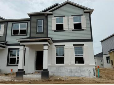 Charming two-story townhome featuring light blue and gray color scheme, white trim, and a covered entryway at 652 Pothos St, Apopka, FL 32703