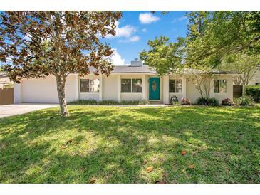 Charming single-story home with a well-manicured lawn, an attached garage, and a vibrant turquoise front door at 821 Sutter Loop, Longwood, FL 32750