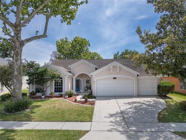 Charming single-story home with a well-manicured lawn, mature trees, and a three-car garage at 115 Oak Grove Cir, Lake Mary, FL 32746