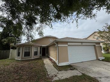Tan single-Gathering home with a white garage door and bay window at 12512 Wisconsin Woods Ln, Orlando, FL 32824