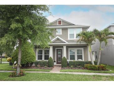 Charming two-story home with a well-manicured lawn, lush landscaping, and inviting front porch at 15849 Sweet Lemon Way, Winter Garden, FL 34787